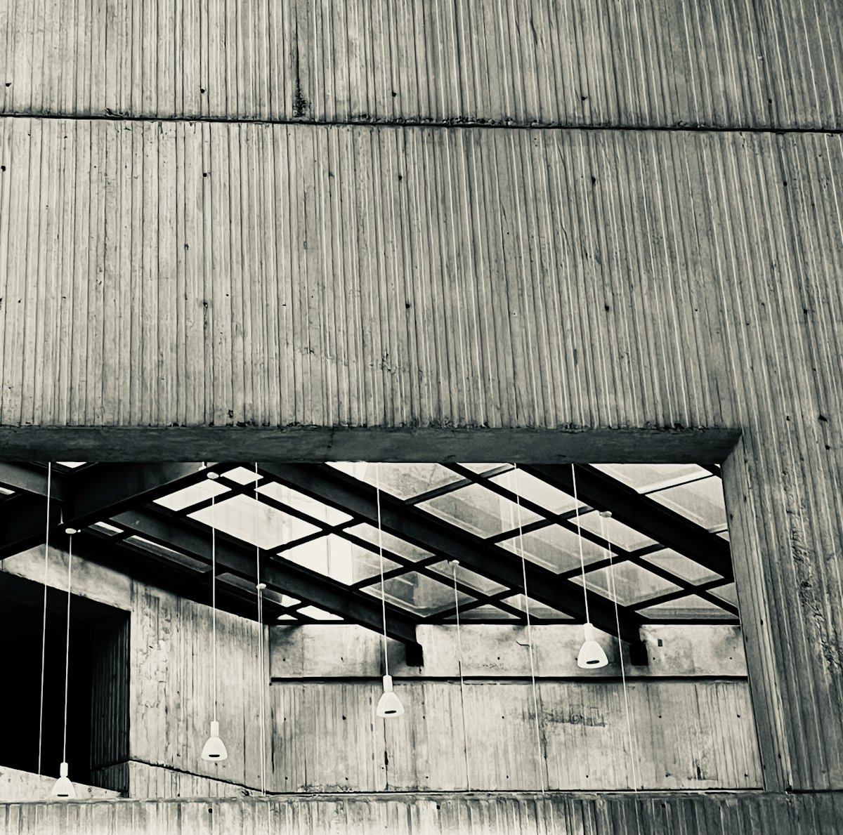 Sunlit concrete interior with a long central opening